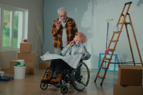 Älterer Mann und Frau im Rollstuhl sind in einer Wohnung, die gerade renoviert wird | Wohnen im Alter